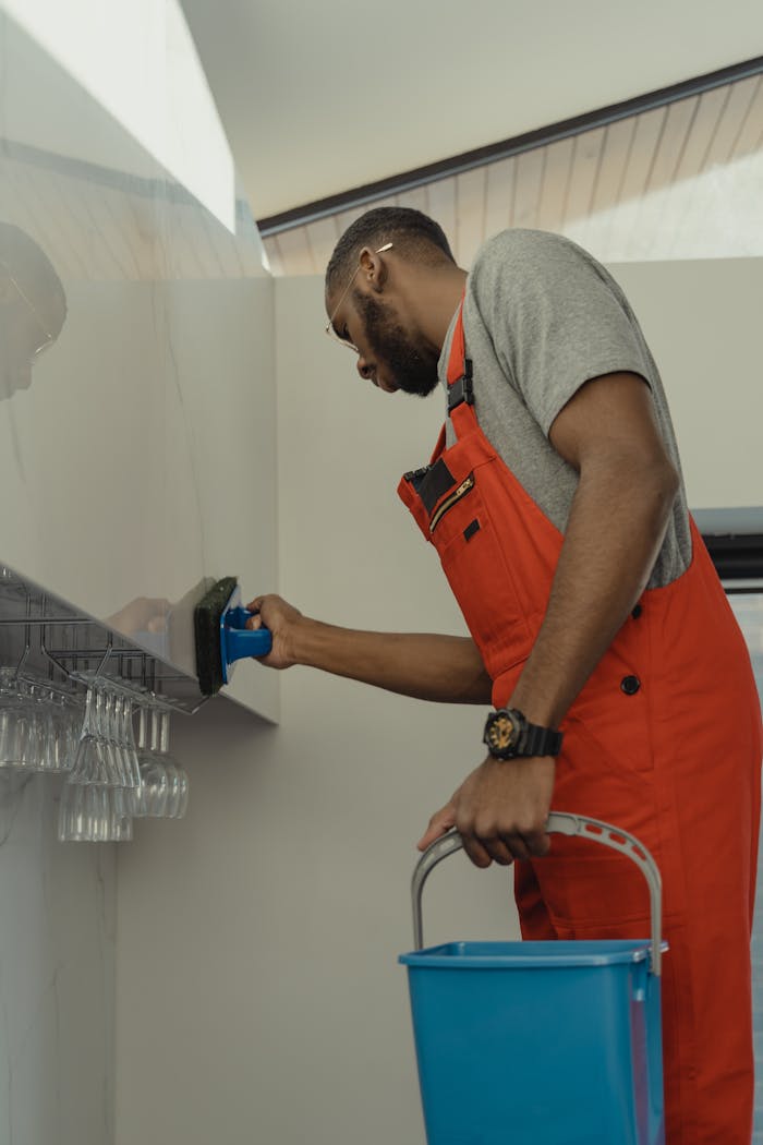About A Man In Gray Shirt Cleaning The Wall 6196687